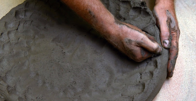 A Manetti craftsman hand-shaping wet terracotta clay